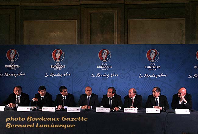 De gauche à droite : Thierry Braillard, Secrétaire d'Etat aux Sports ; Patrick Kanner, Ministre de la Ville, de la Jeunesse et des Sports ; Manuel Valls, Premier Ministre ; Alain Juppé, Maire de Bordeaux et Président du Comité des villes hôtes de l'Euro 2016 ; Michel Platin ; Jiacques Lambert, Président Euro 2016 SAS ; Noël Le Graët, Président de la FFF et Gianni Infantino, Secrétaire Général de l'UEFA