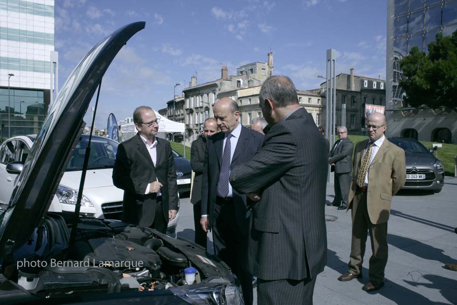 Alain Juppé admire le dernier né hybride de chez Peugeot